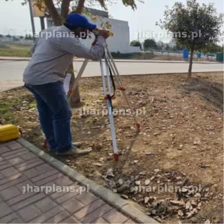 Surveyor Conducting Land Measurement Work at Construction Site