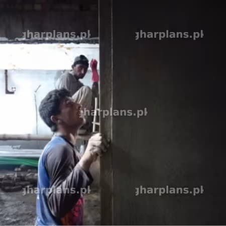 Construction Worker Checking the Vertical Alignment of a Wall