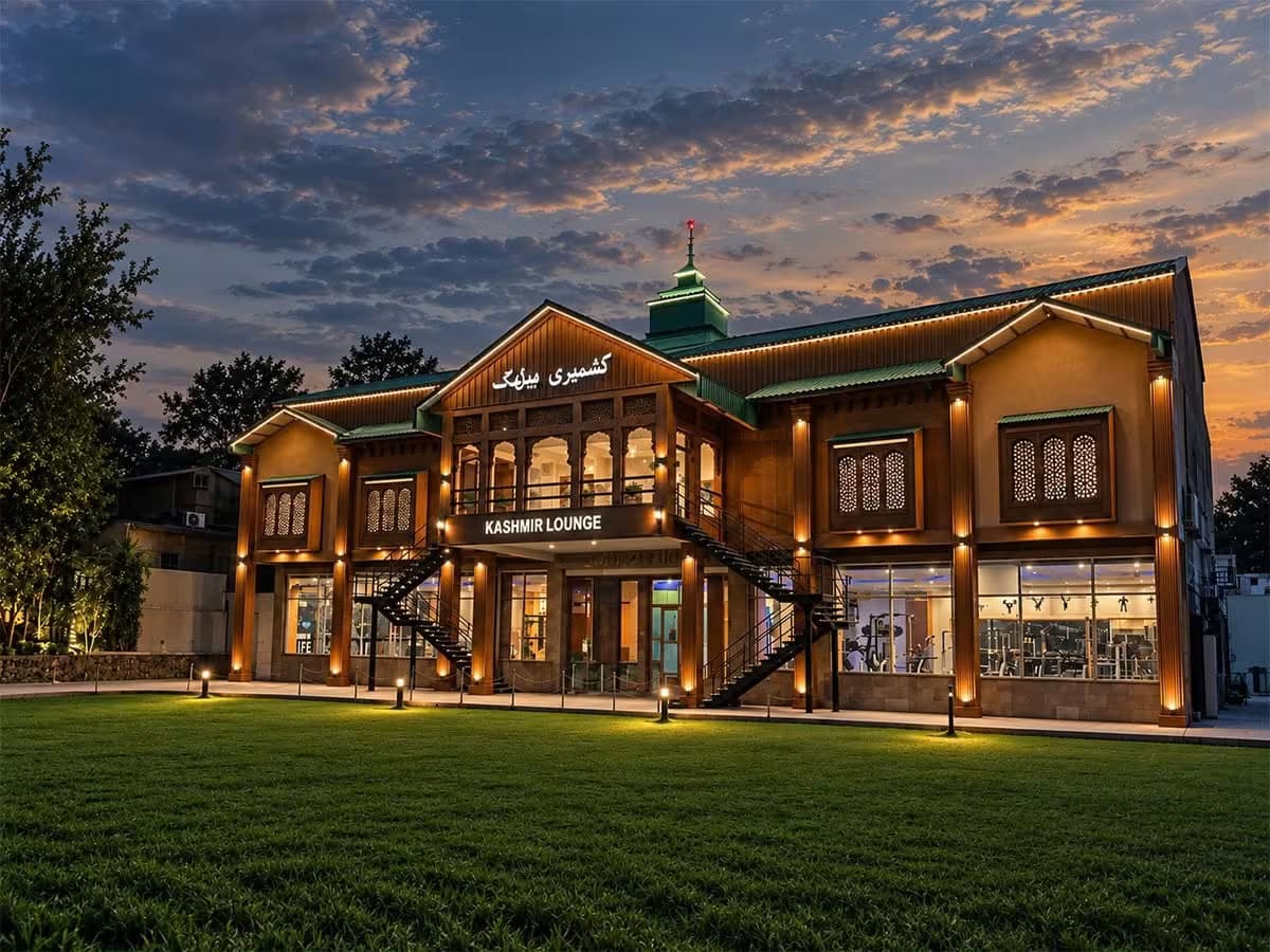 Kashmir Lounge Museum exterior showing traditional Kashmiri architecture with carved wooden windows, warm lighting and landscaped grounds