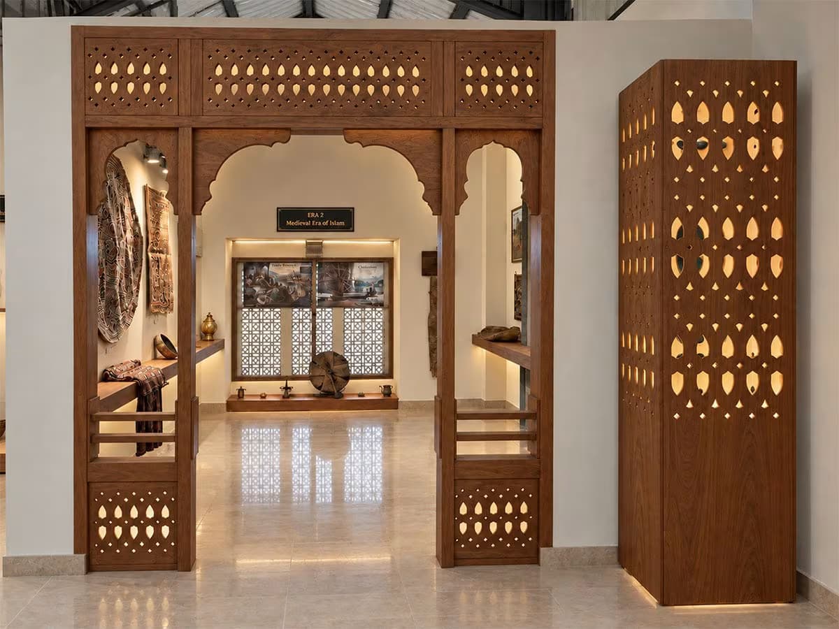 Carved wooden arch with traditional Kashmiri pinjrakari lattice panels at Kashmir Lounge Museum showing heritage craftsmanship